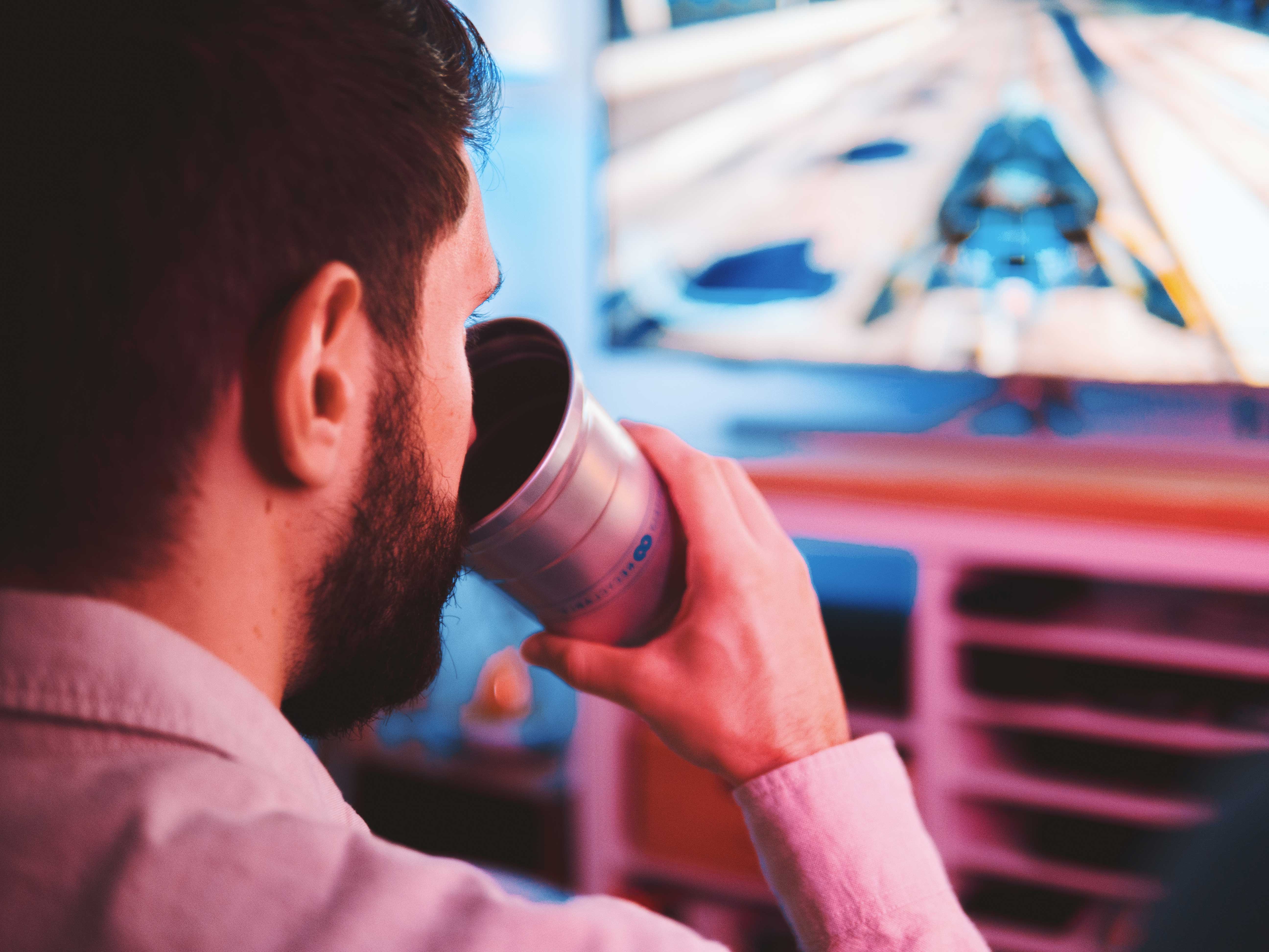 person drinking from a ball aluminum cup