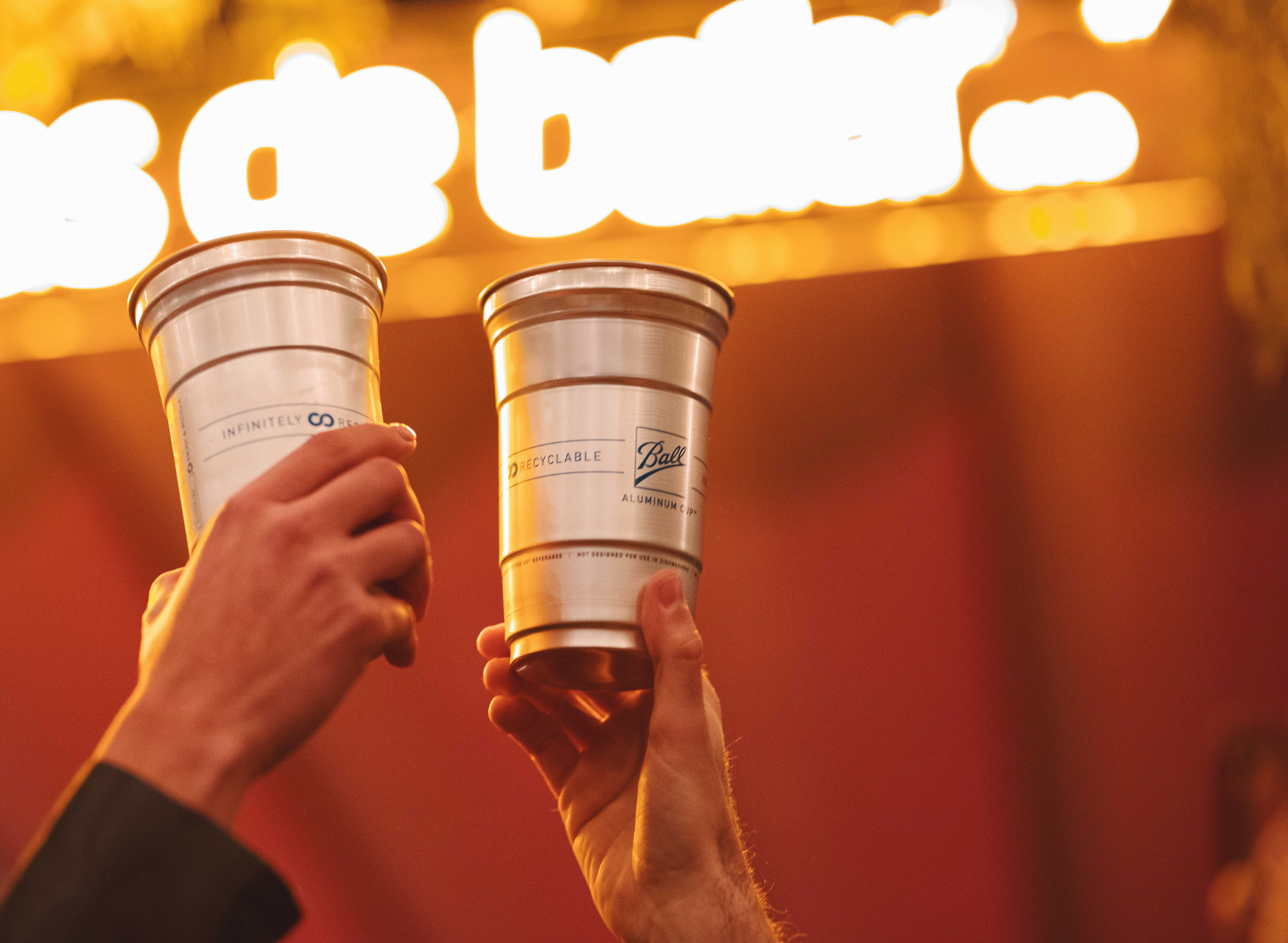 Two Ball Aluminum Cups held in a cheers motion