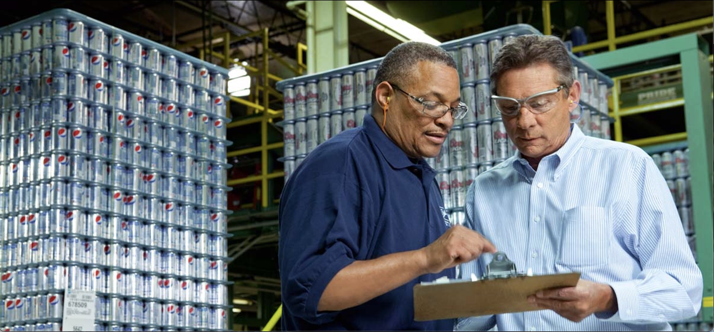 two people in a warehouse reviewing a document