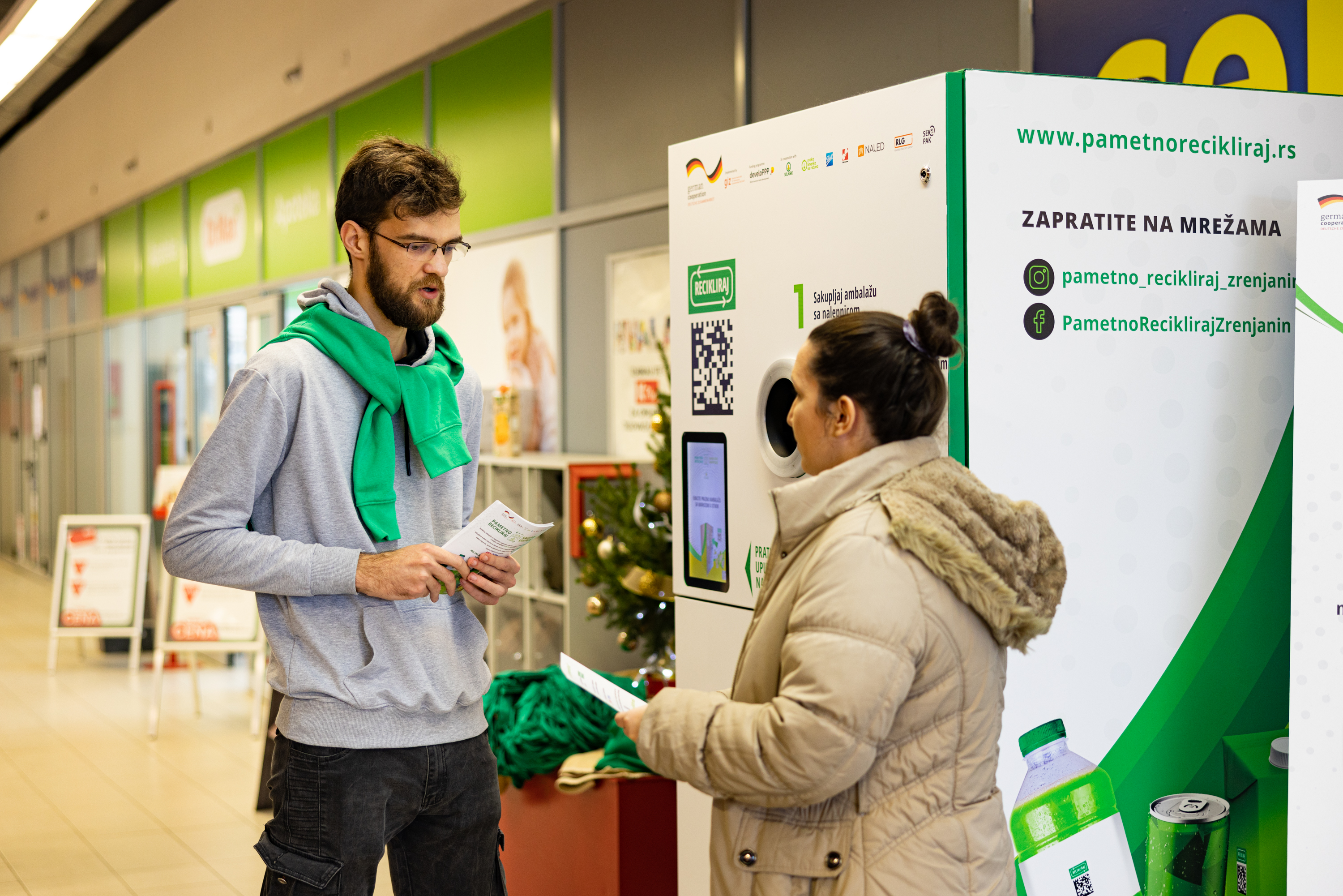 People standing at a recycling kiosk