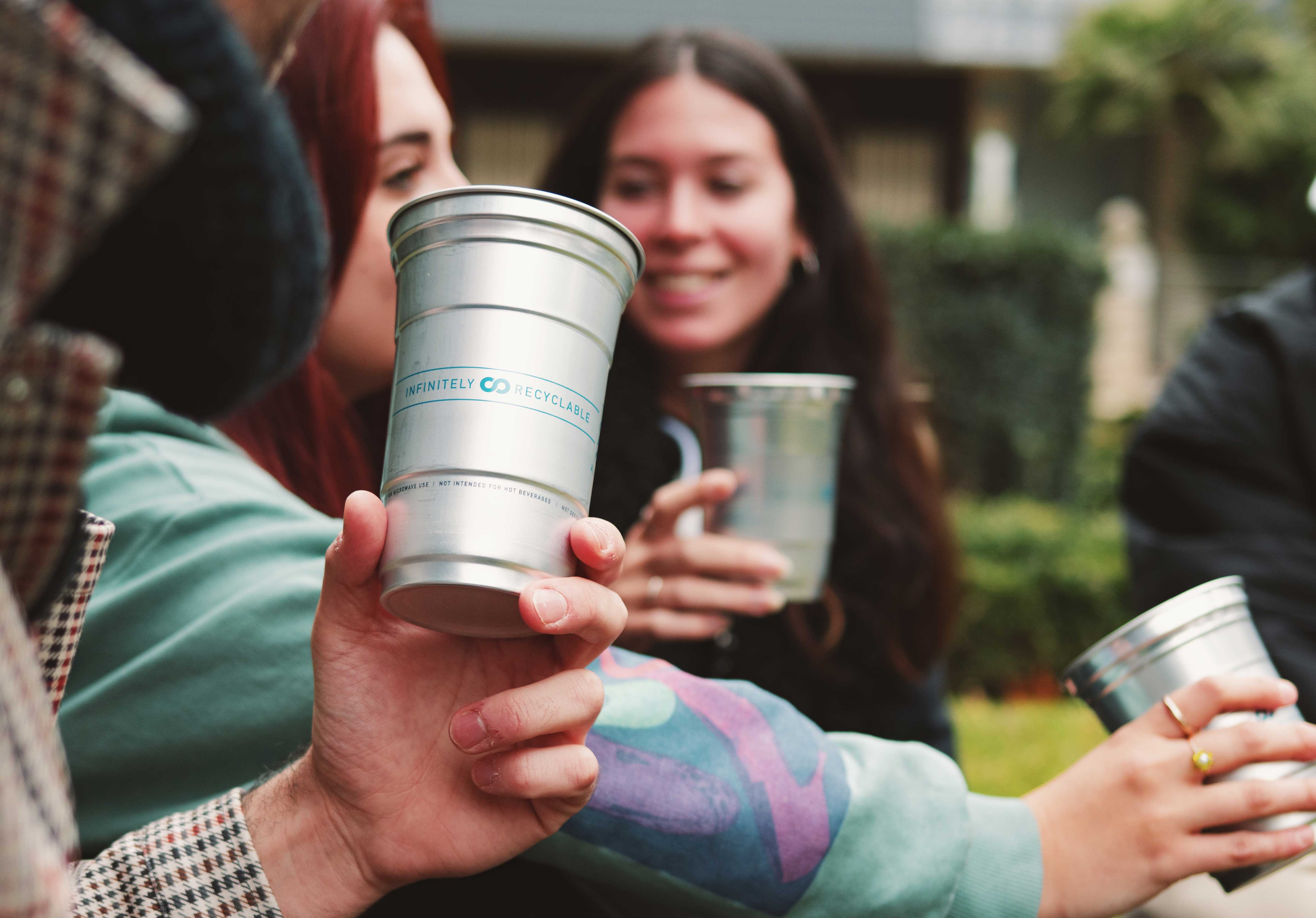 People outside holding Ball Aluminum Cups