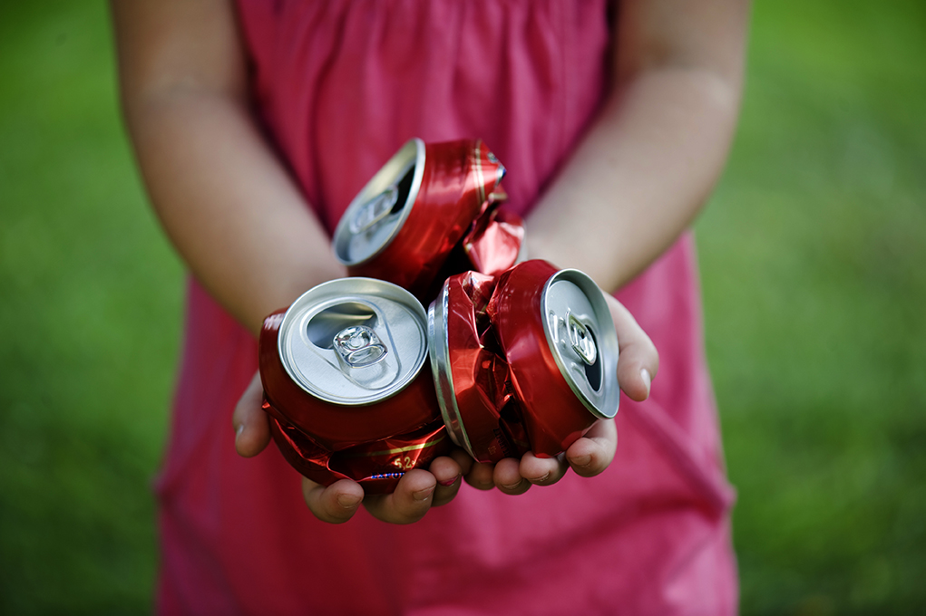 Hands holding crushed aluminum cans